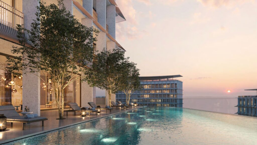 View of the Four Seasons Private Residence DIFC swimming pool with a stunning cityscape and sunset background.